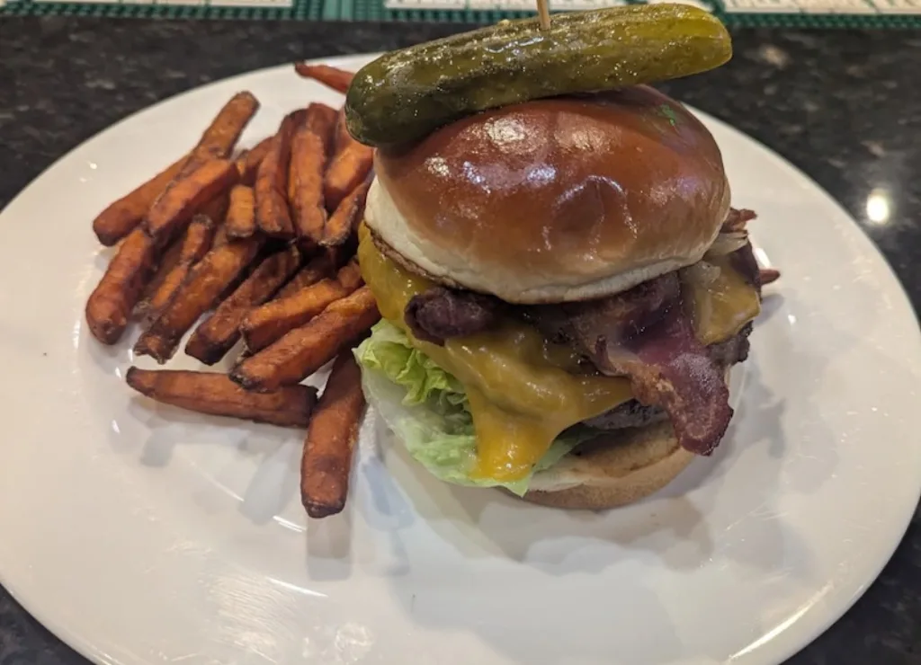 Juicy bacon cheddar burger served with sweet potato fries at Longley's Restaurant.