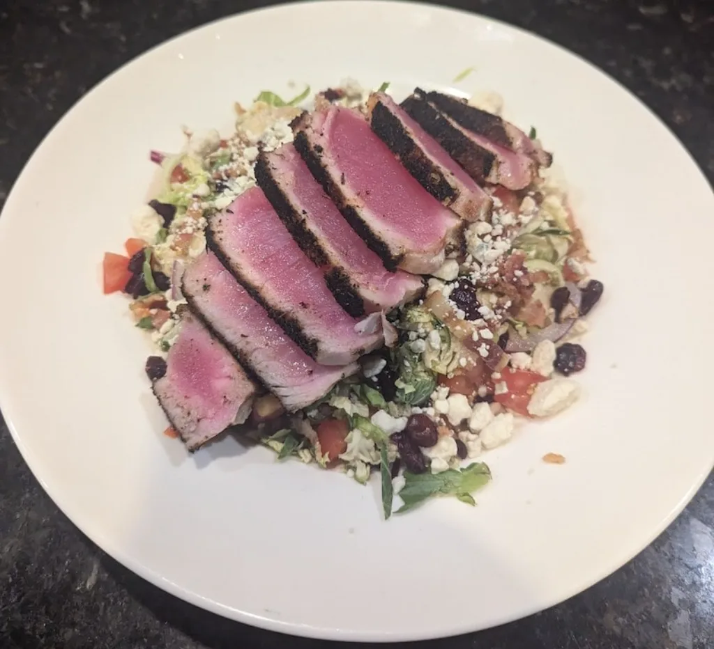 Blackened tuna steak salad topped with blue cheese crumbles.