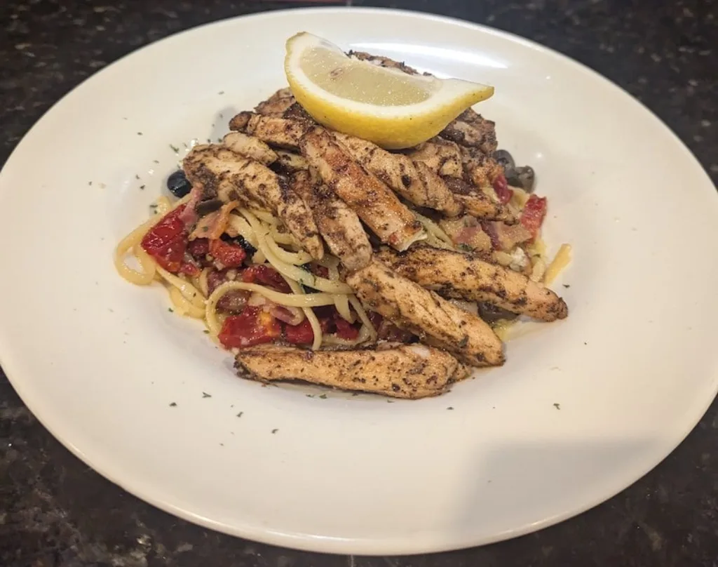 Grilled chicken pasta tossed with sun-dried tomatoes for a savory dinner.