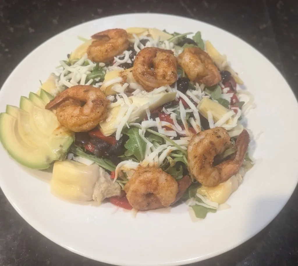 Grilled shrimp Mediterranean salad with avocado slices.