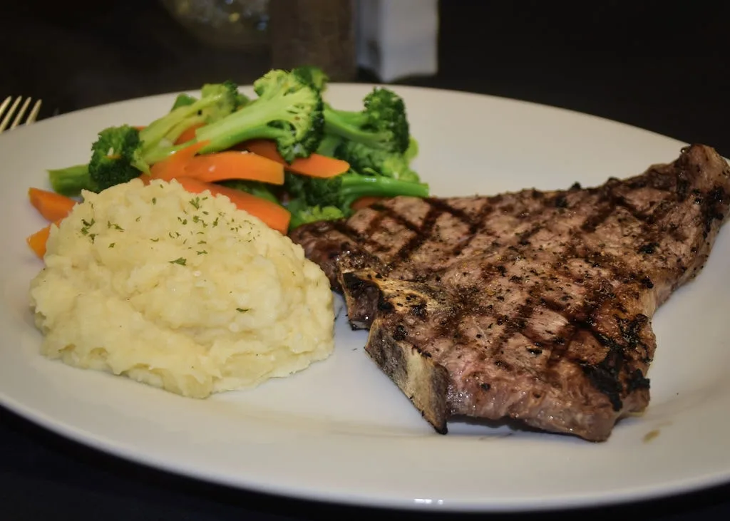 Grilled T-Bone steak served with creamy mashed potatoes at Longley's.