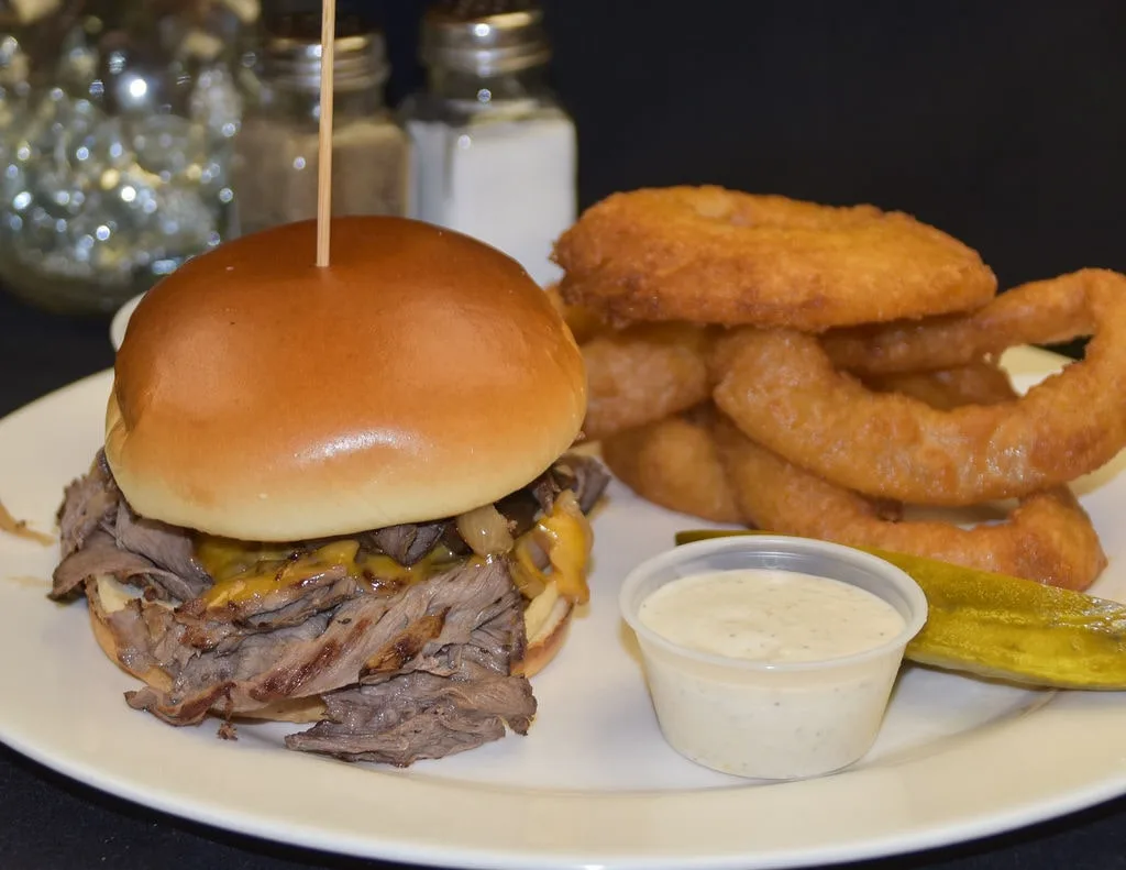 Roast beef and cheddar sandwich served with crispy onion rings in Branford.