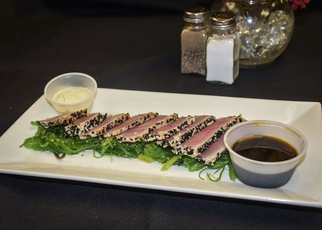 Sesame seared tuna appetizer served with seaweed salad.