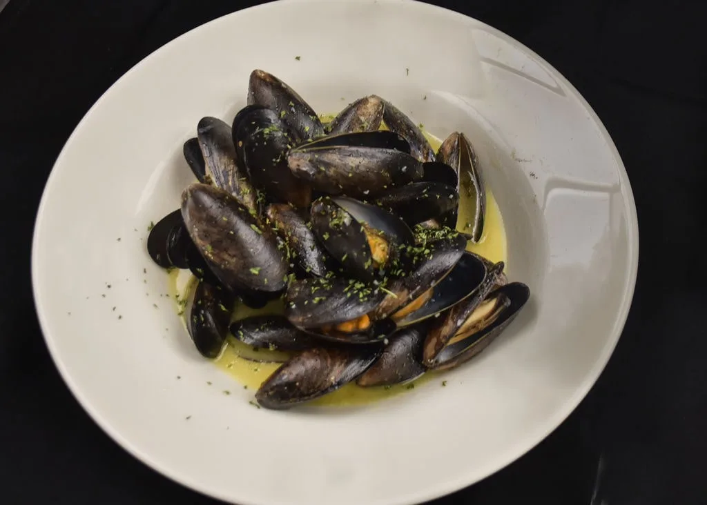 Overhead view of a bowl of fresh steamed mussels.