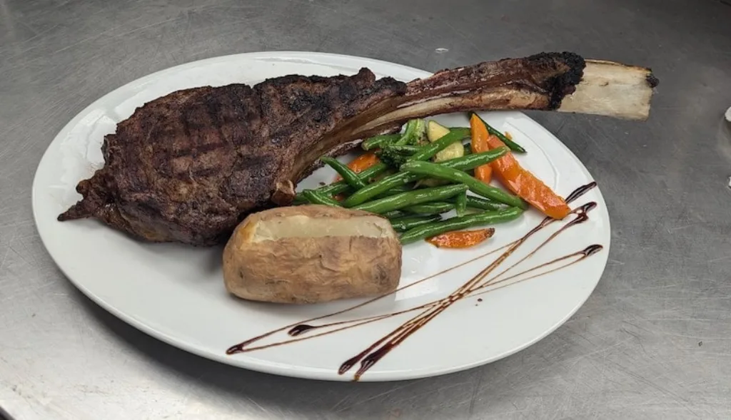 Massive Tomahawk Ribeye steak dinner for the ultimate meat lover at Longley's.